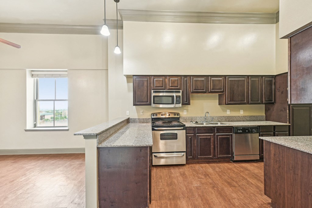 A kitchen with wooden cabinets and a stainless steel oven.