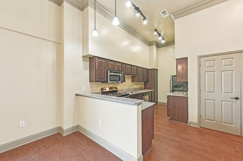 A kitchen with a white counter and brown cabinets.
