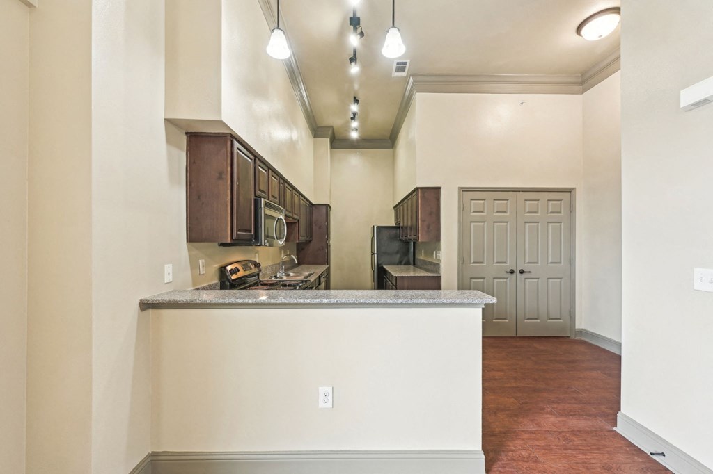 A kitchen with a white counter and brown cabinets.