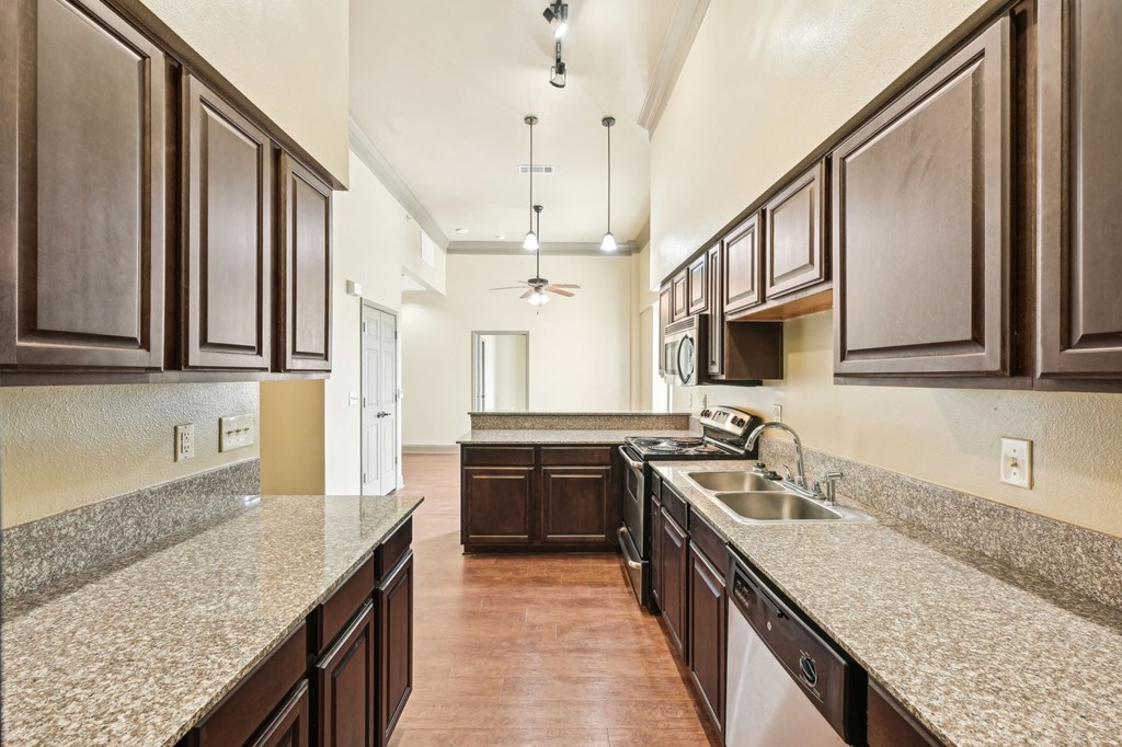 A kitchen with brown cabinets and a white counter top.