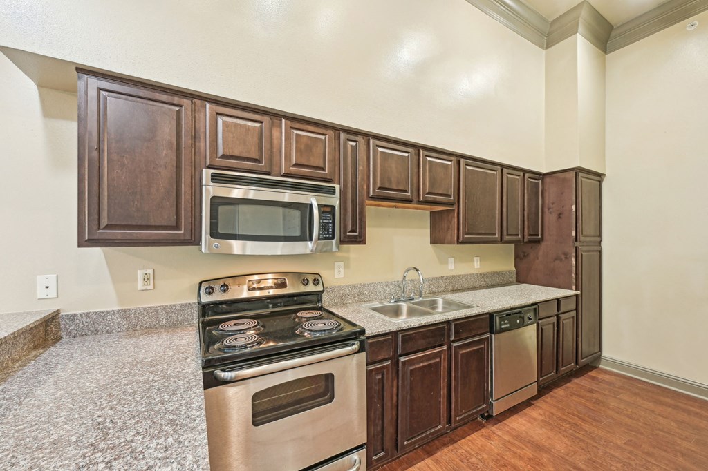 A kitchen with brown cabinets and stainless steel appliances.