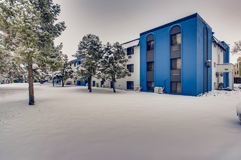 A blue building is surrounded by snow.