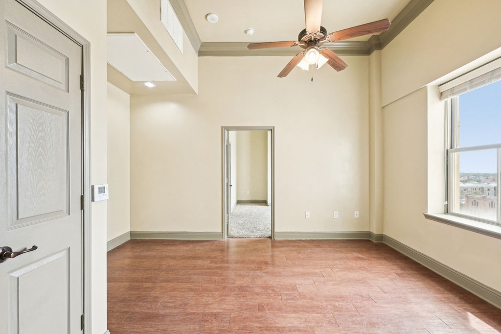 A room with a ceiling fan and a door.