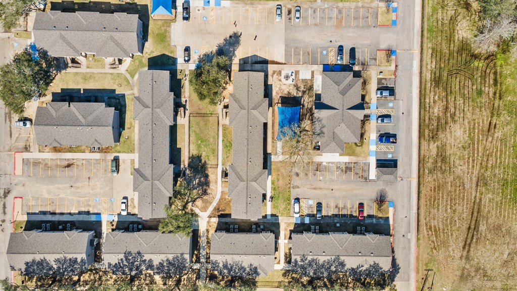 an aerial view of a neighborhood with roofs covered in blue tarps