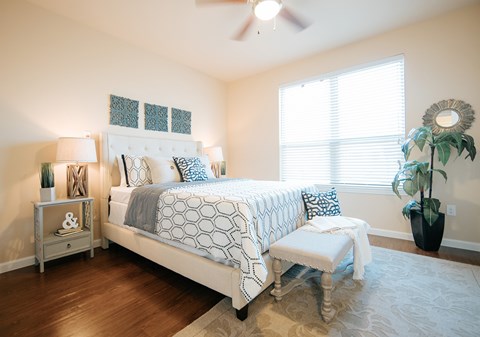 A bedroom with a large bed and a bench in front of it.