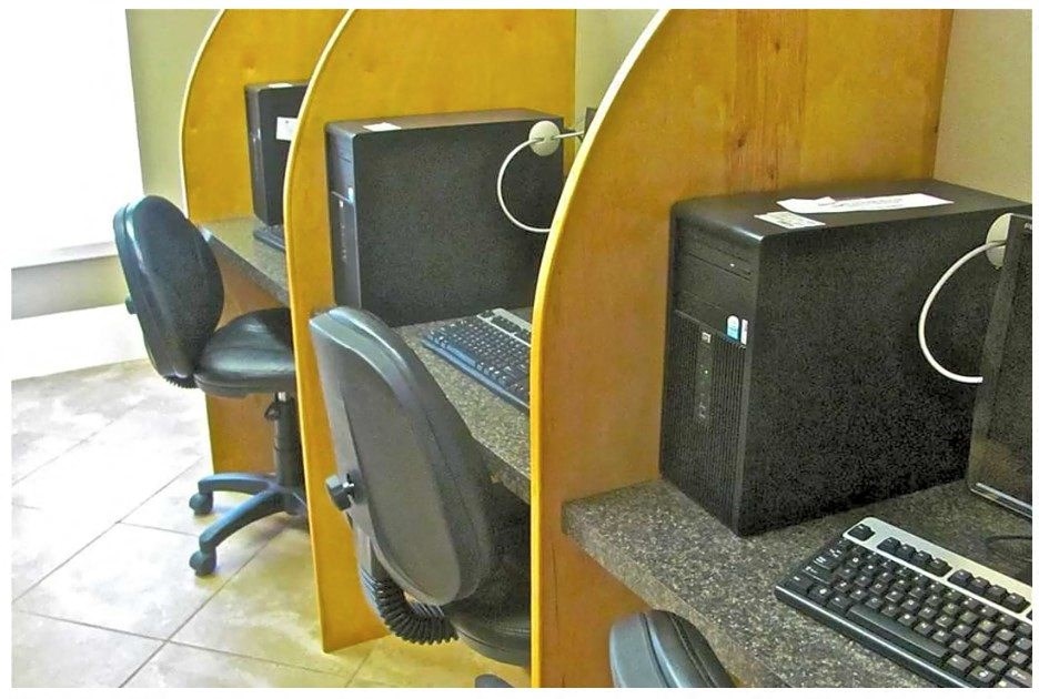 a computer sitting on top of a desk next to a chair