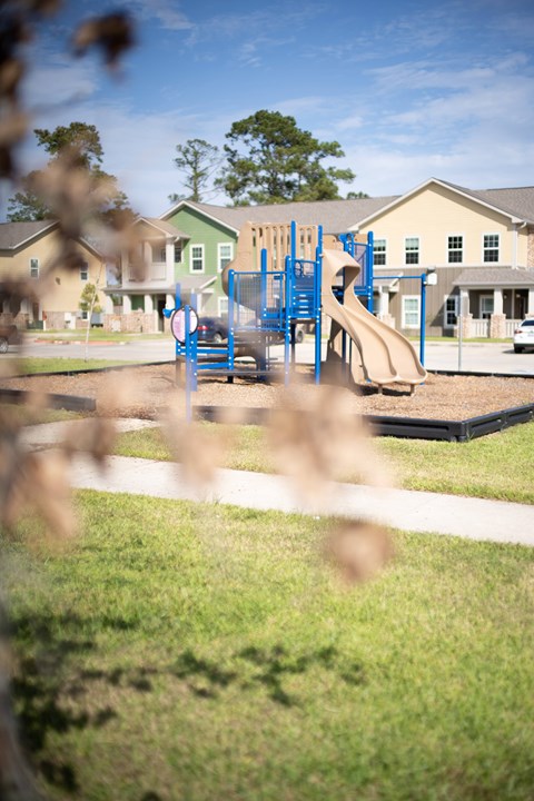 A playground with a blue slide and a red and white sign.