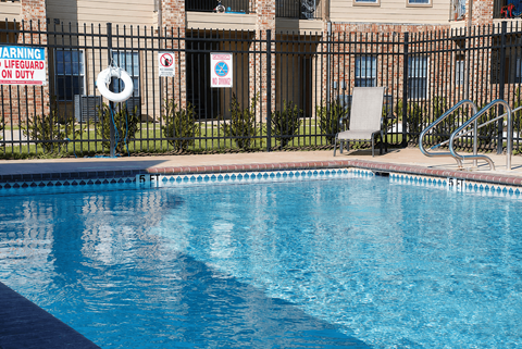 A pool with a warning sign and a life guard on duty.