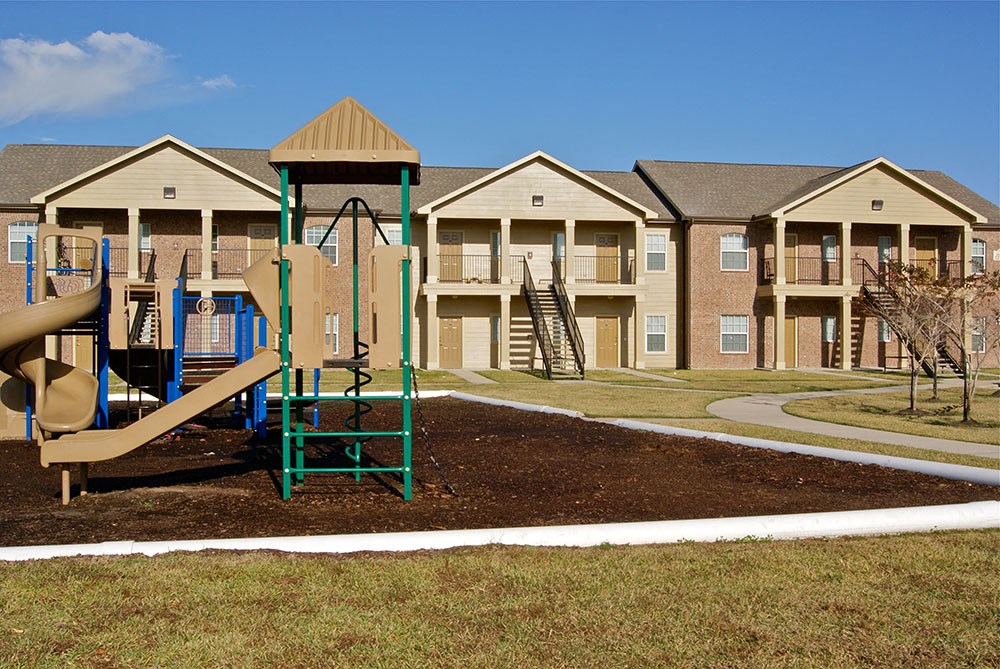 an empty playground in front of an apartment complex