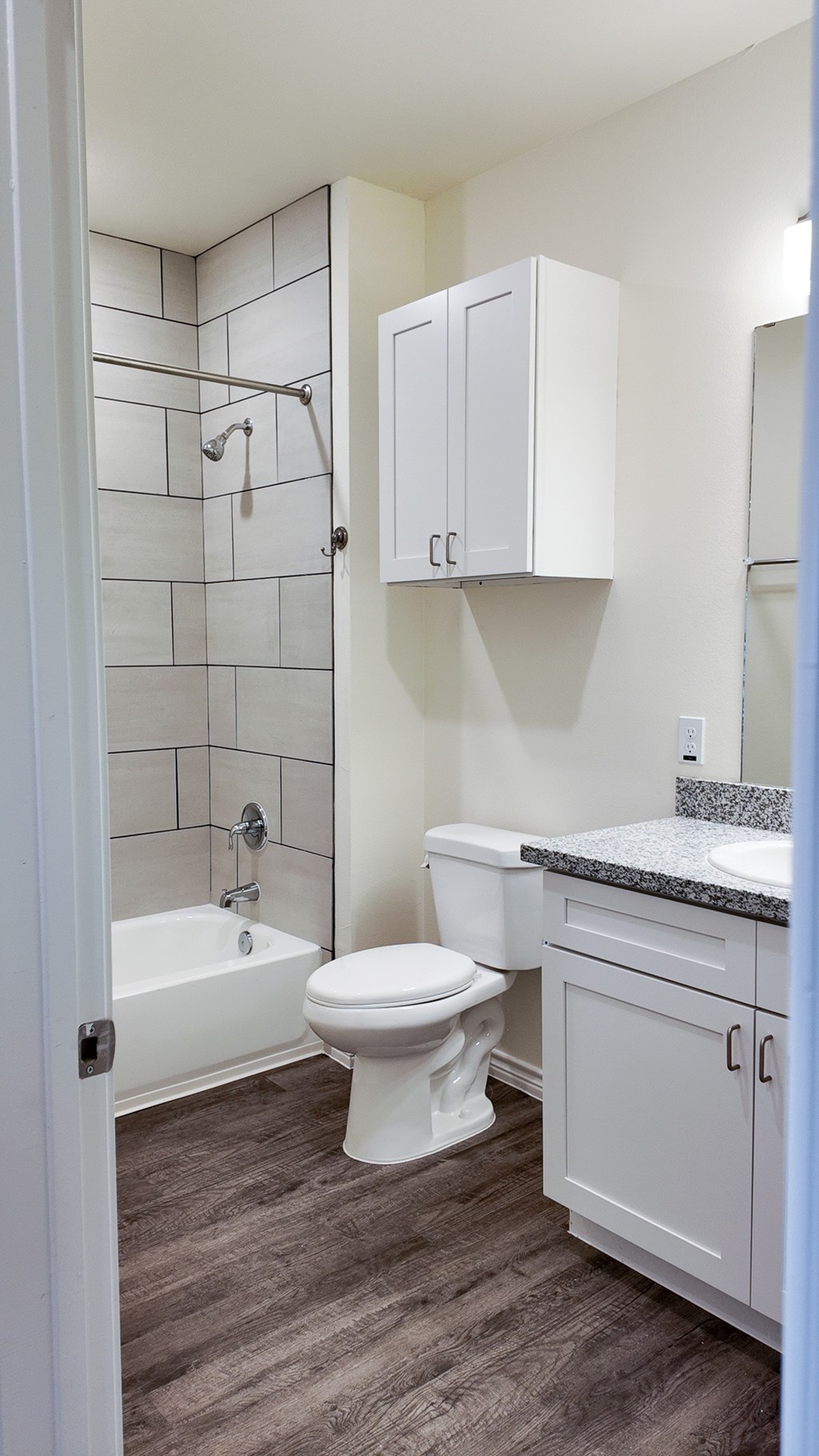 A white toilet sits in a bathroom next to a white sink.