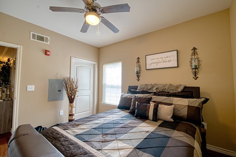 A bedroom with a large bed and a ceiling fan.