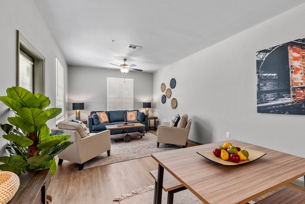 a living room with couches and a table with a bowl of fruit