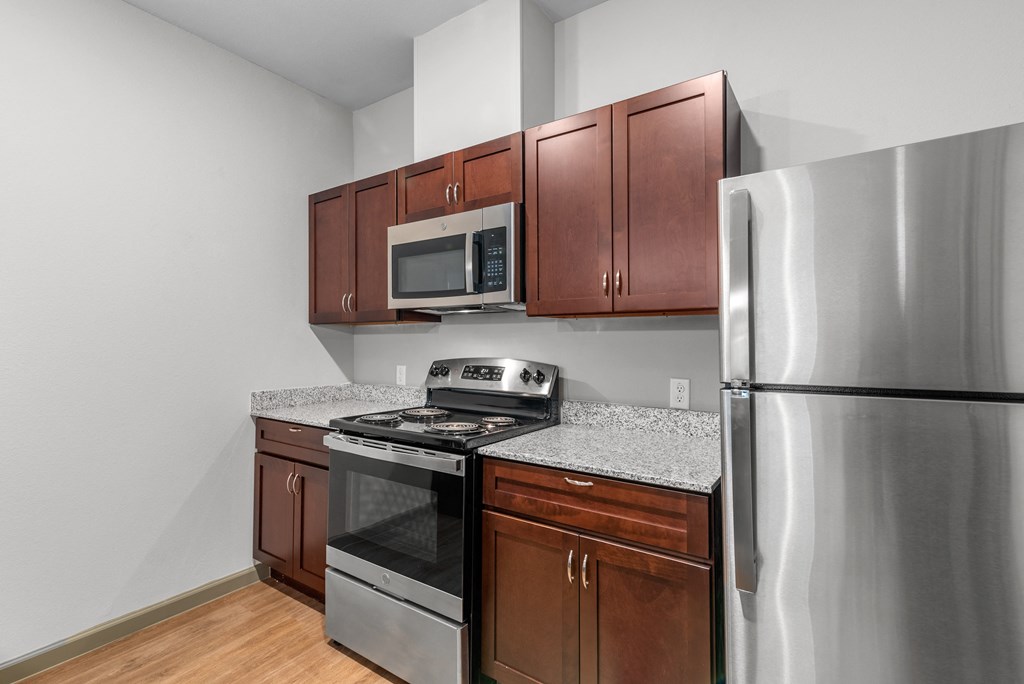an empty kitchen with stainless steel appliances and granite counter tops