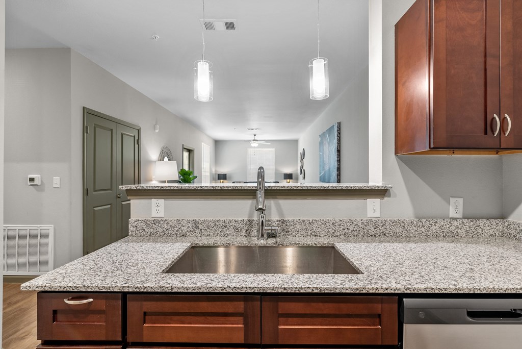 a kitchen with granite counter tops and a stainless steel sink