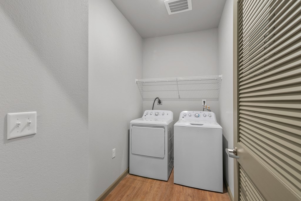 a laundry room with two washers and a dryer in it
