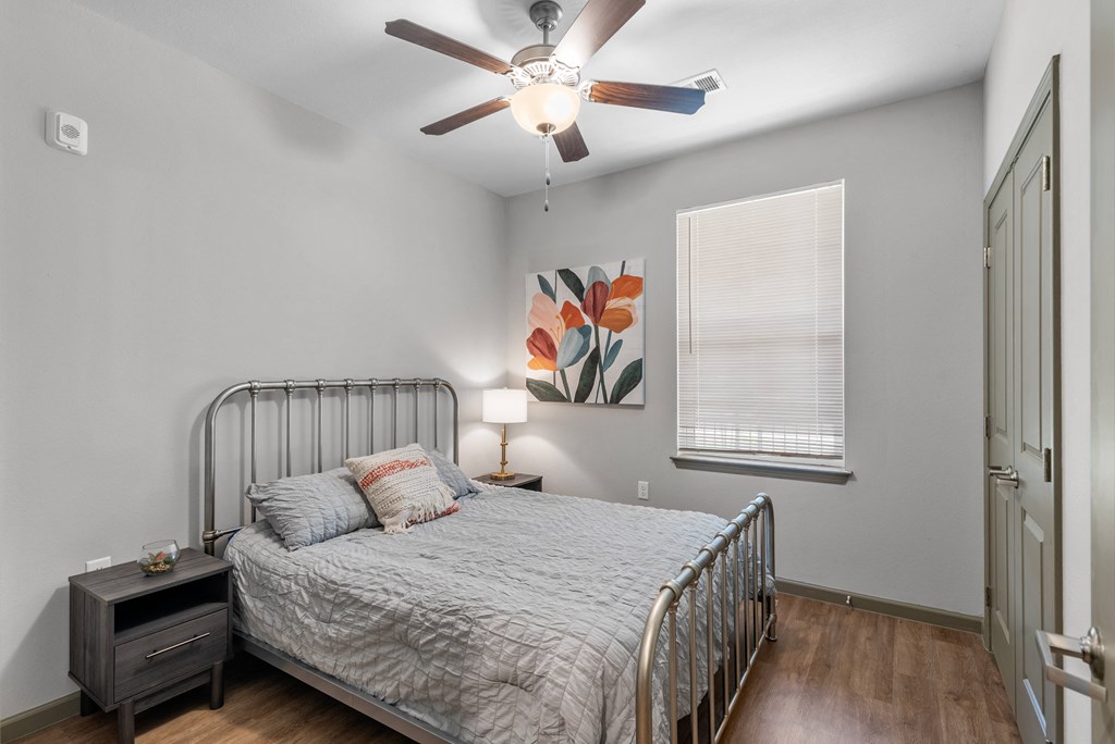 a bedroom with a bed and a ceiling fan
