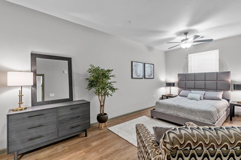 a bedroom with a bed and a dresser with a mirror