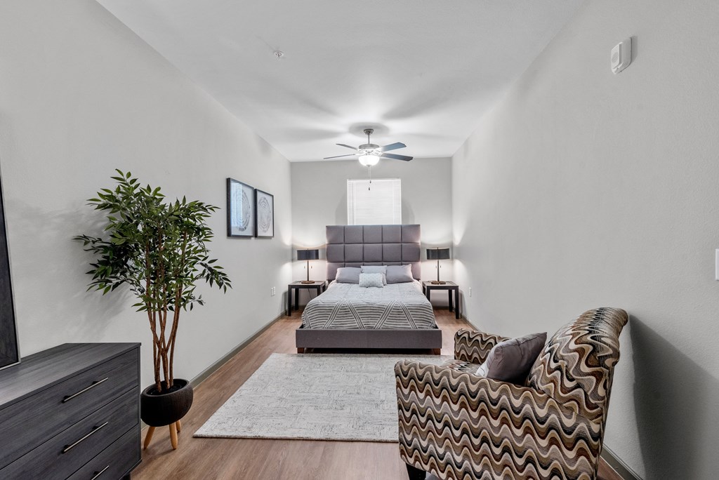 a bedroom with a couch and a bed and a ceiling fan
