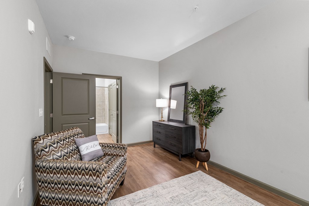 a living room with a couch and a dresser and a door to a bathroom