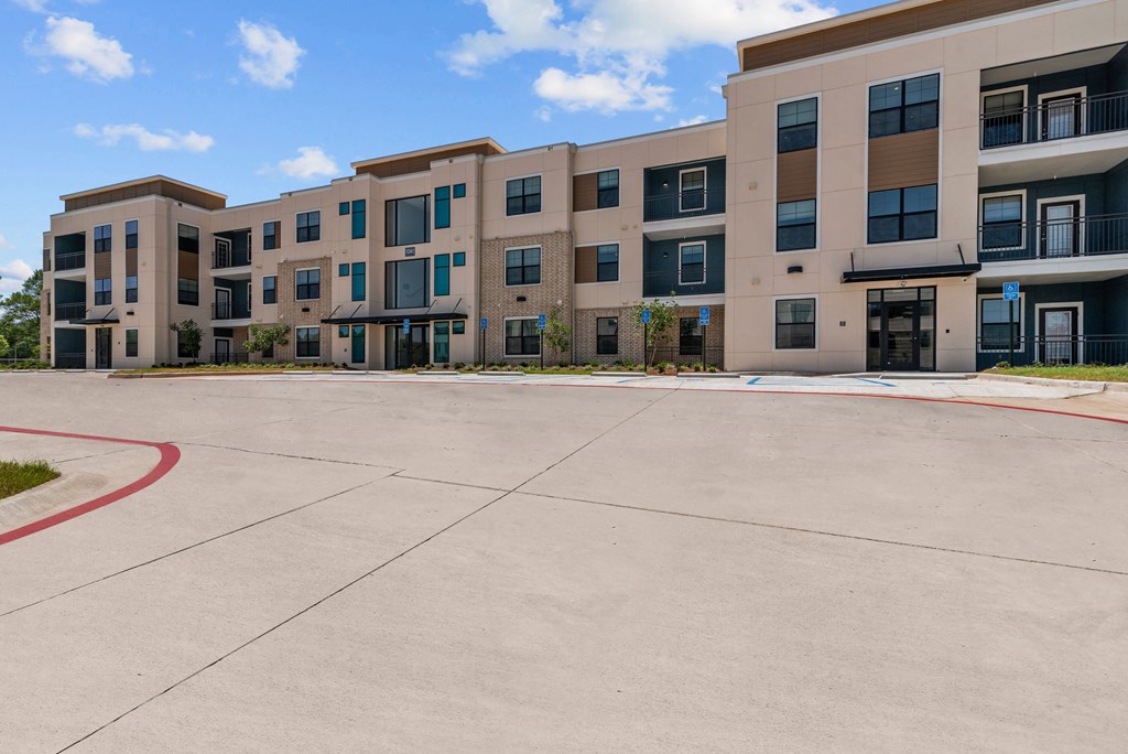 an empty parking lot in front of an apartment building