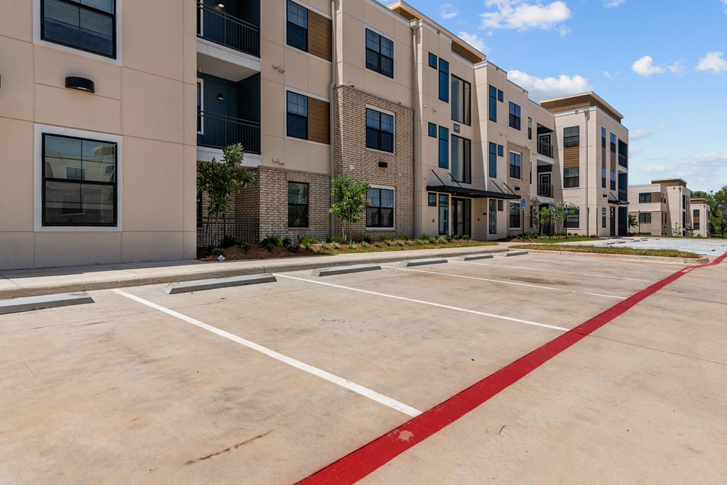 an empty parking lot in front of an apartment building