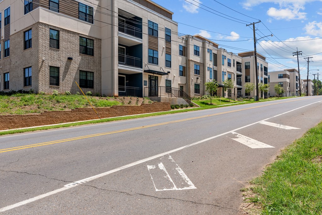 an empty street with an apartment building on the side of it