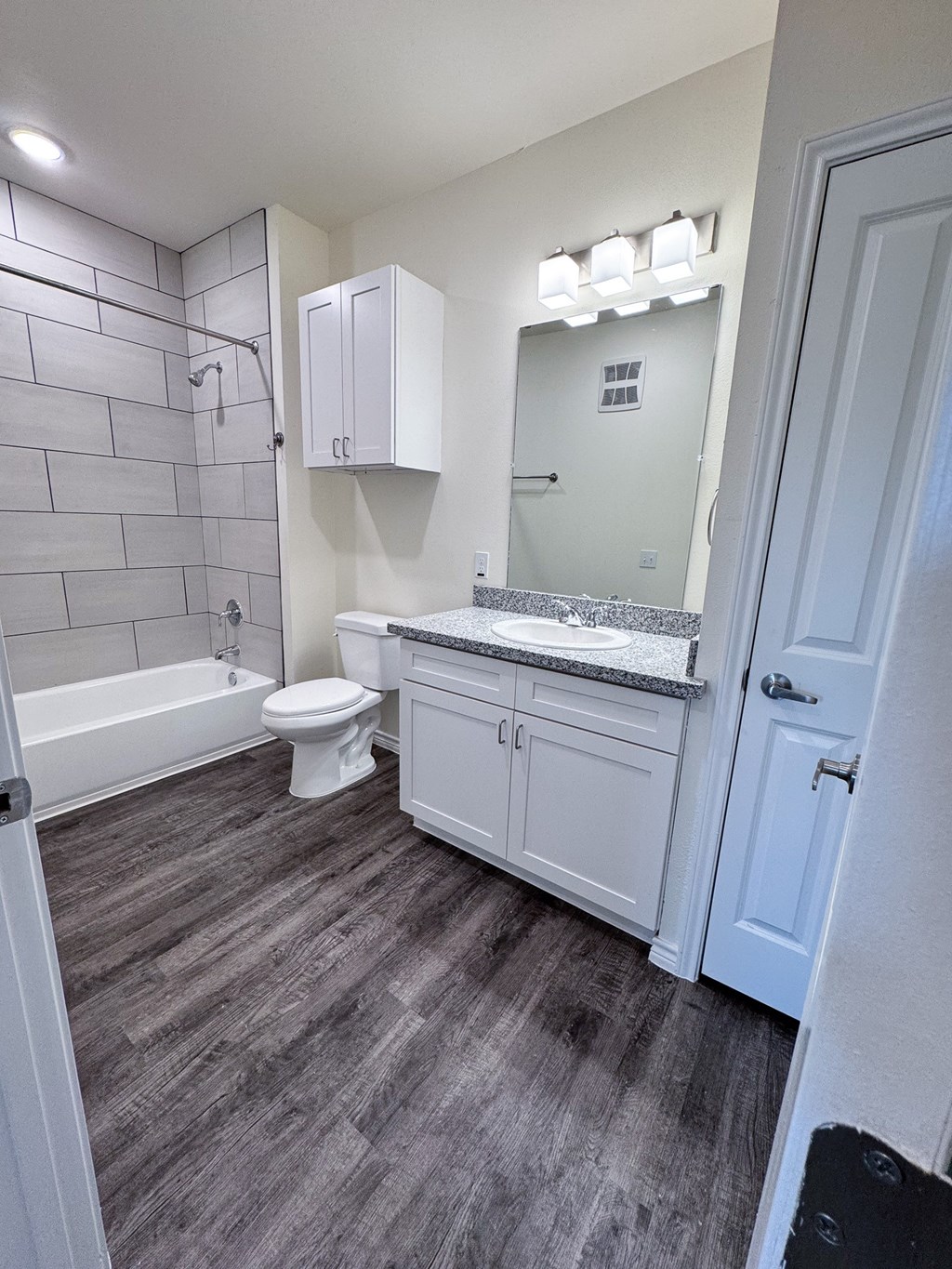 A bathroom with a toilet, sink, and bathtub.