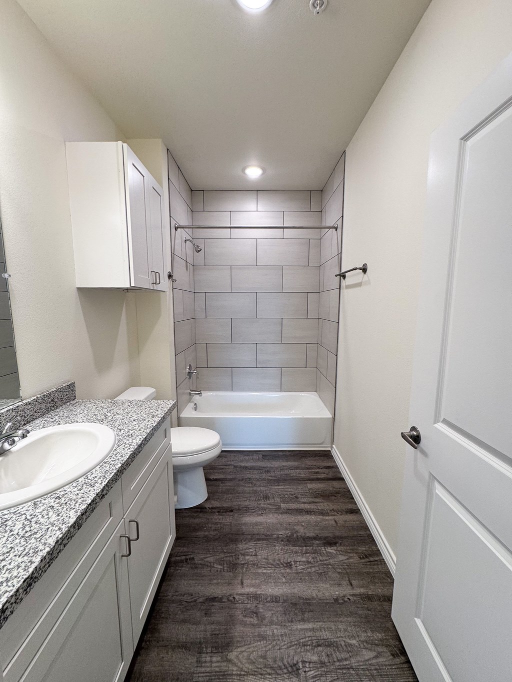 A bathroom with a white toilet, sink, and bathtub.