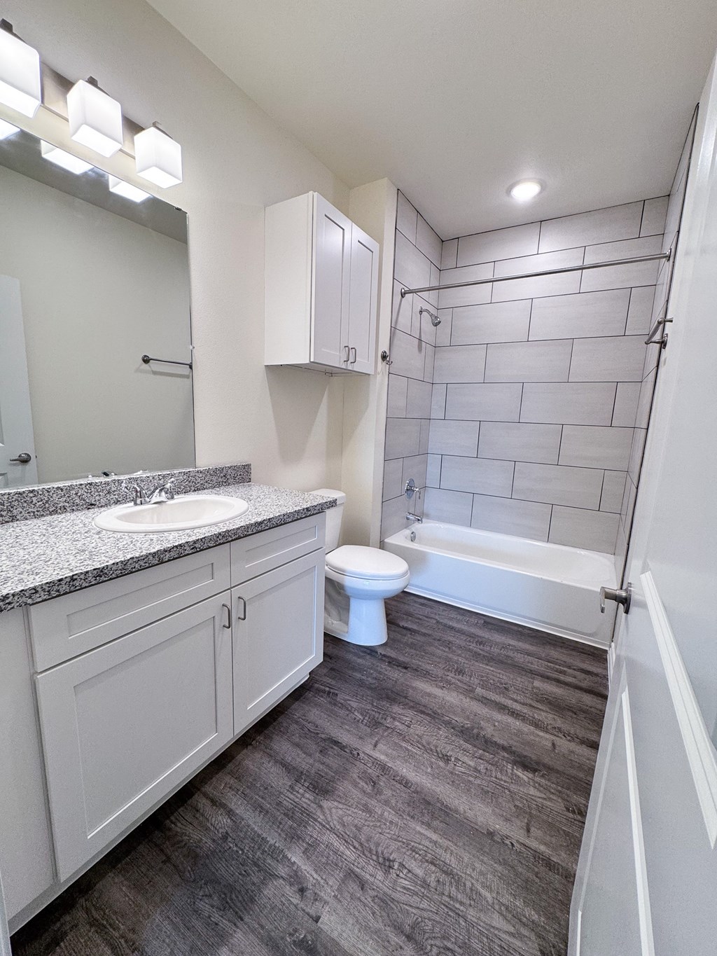 A white bathroom with a toilet, sink, and bathtub.