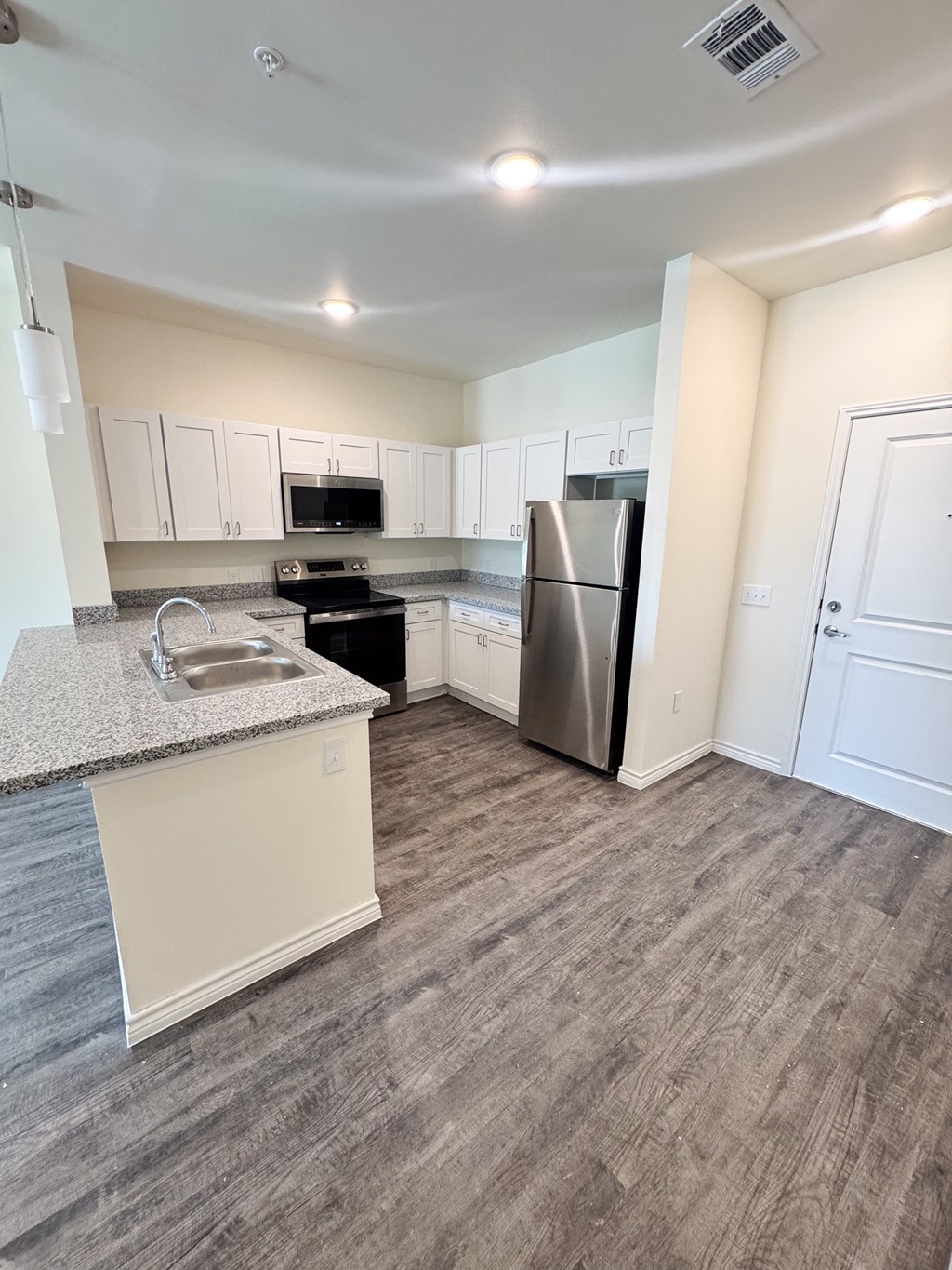 A kitchen with a sink, stove, and refrigerator.
