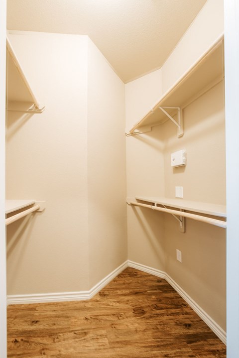 A white wall with a light switch and a white shelf.