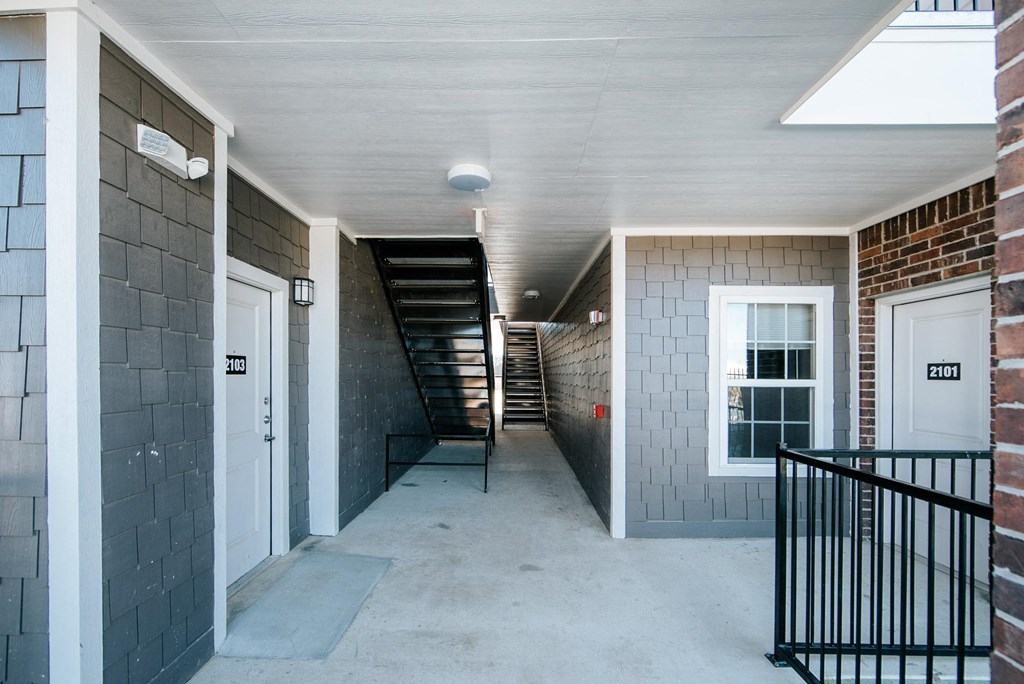 a hallway with two doors and a staircase in the background
