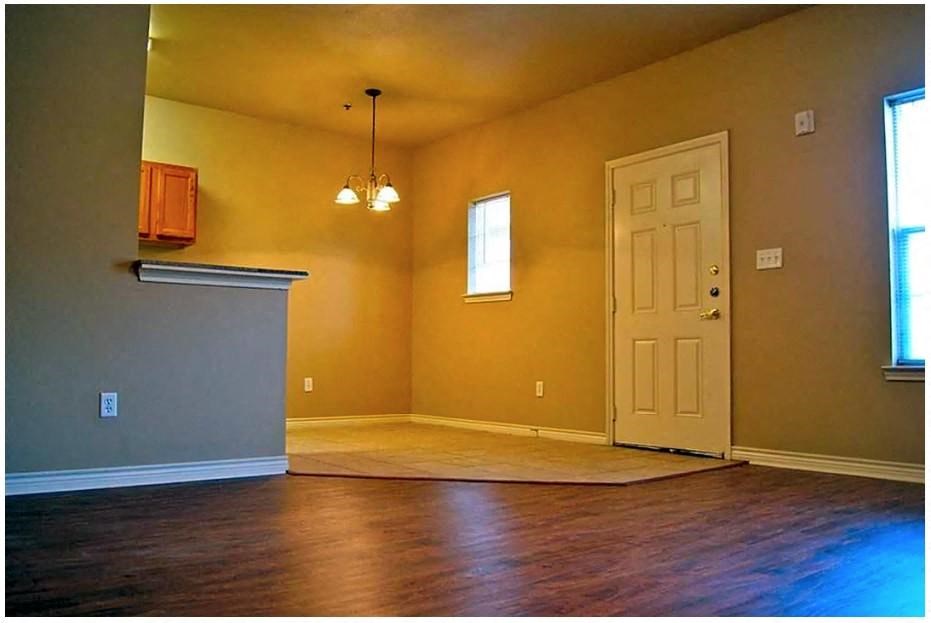 an empty room with a door and a chandelier