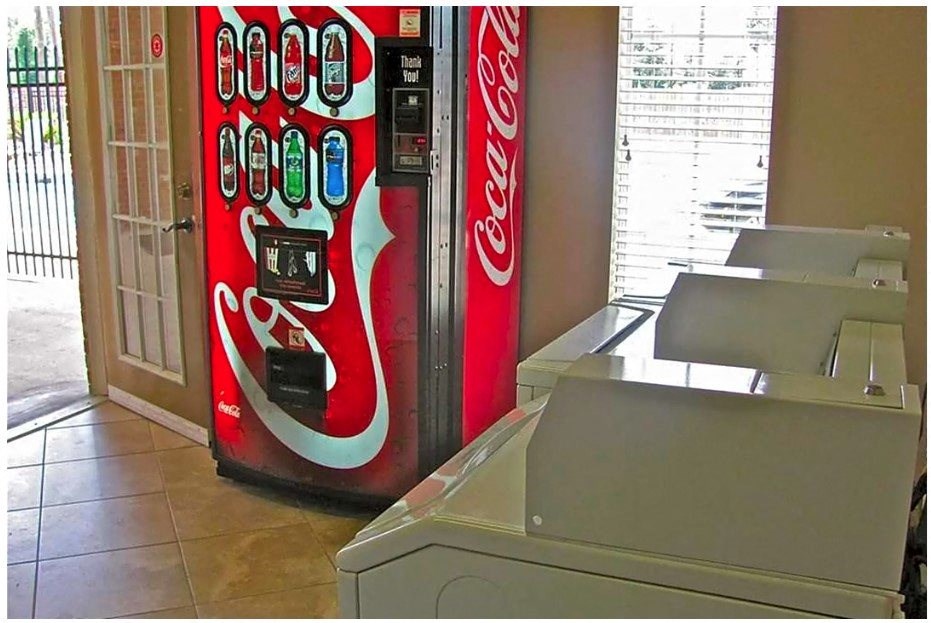 a coca cola vending machine in a laundromat