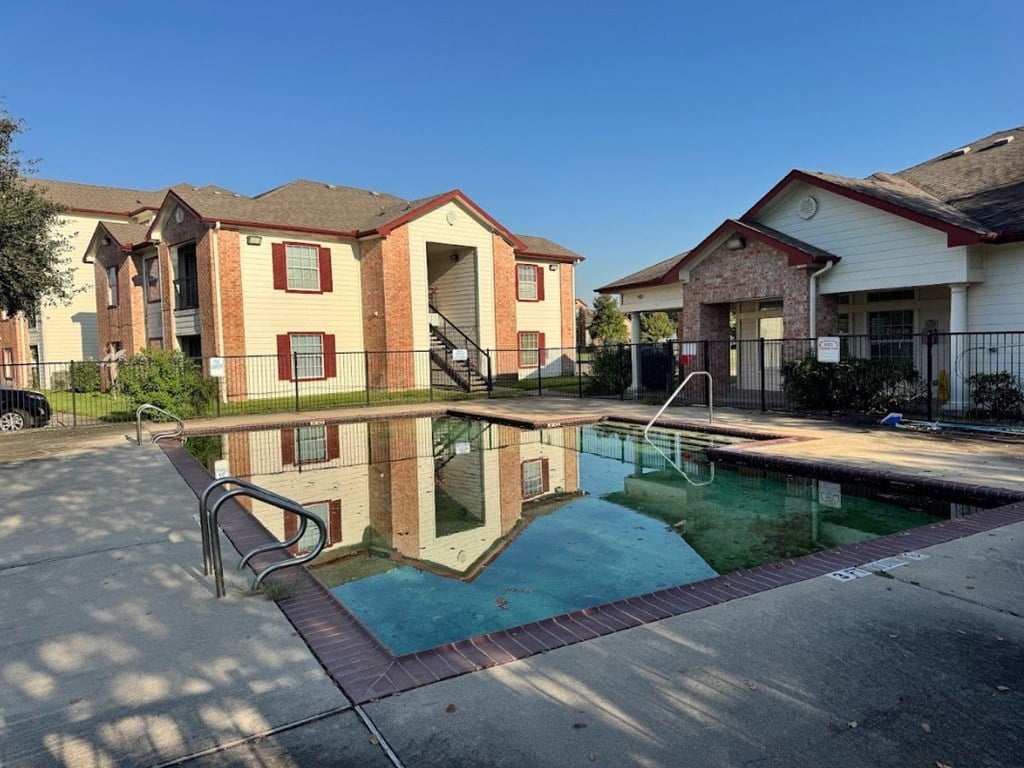 A swimming pool in front of apartment buildings.
