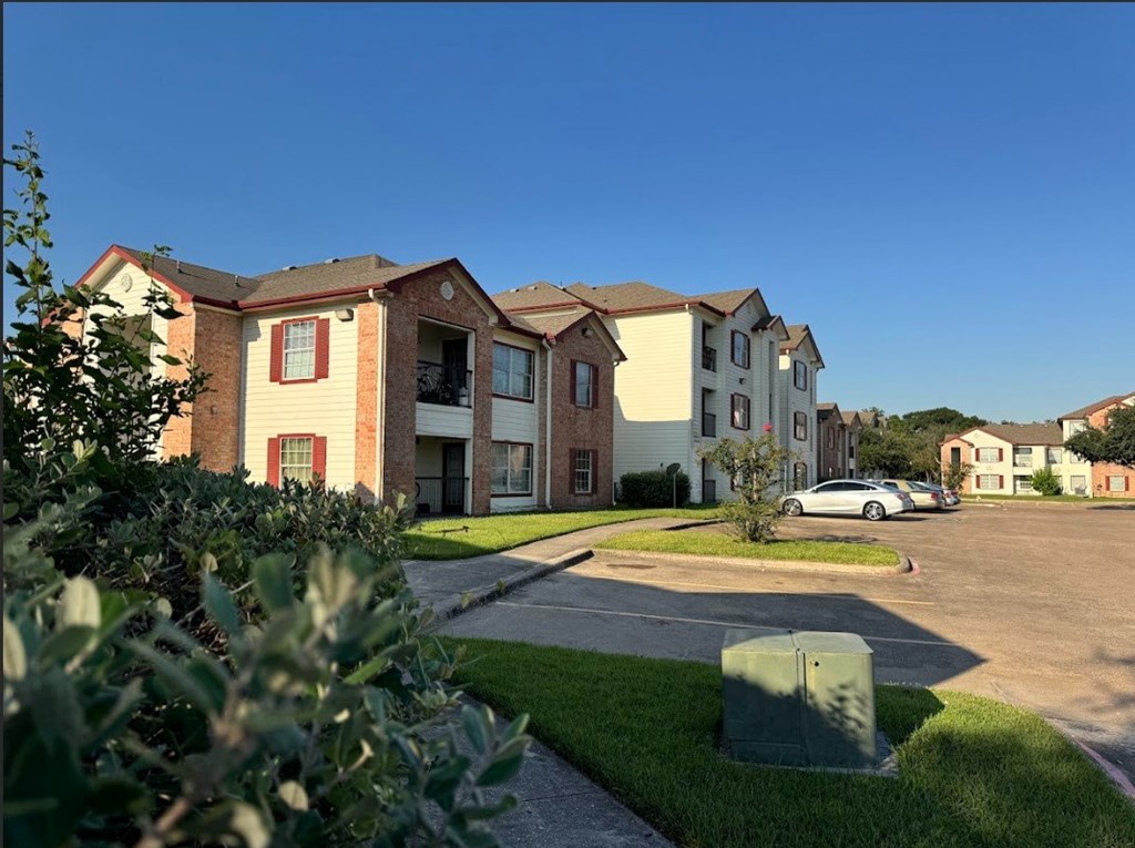 A row of houses with a car parked in the driveway.