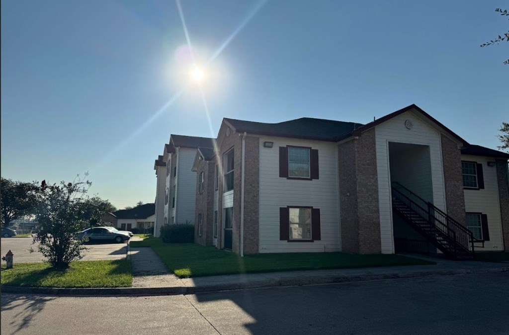 A sunny day at a residential area with houses and a car parked on the street.