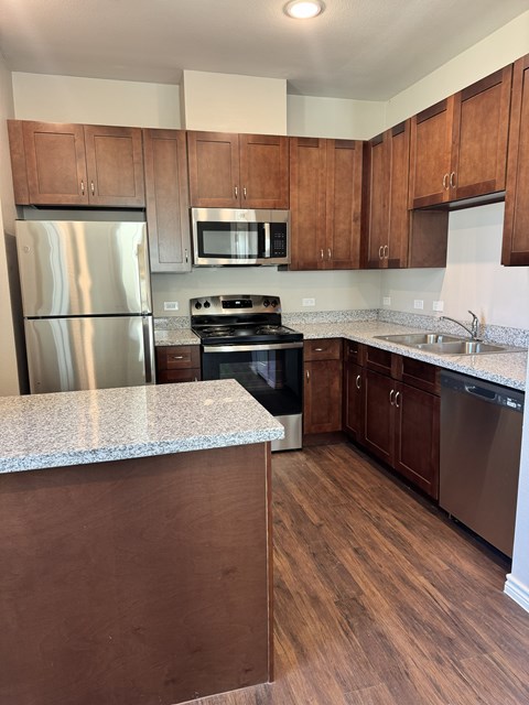 A kitchen with wooden cabinets and a stainless steel refrigerator.