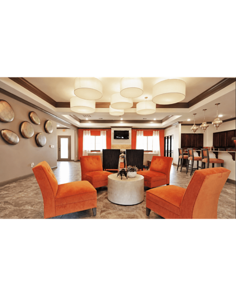 A living room with orange chairs and a fireplace.