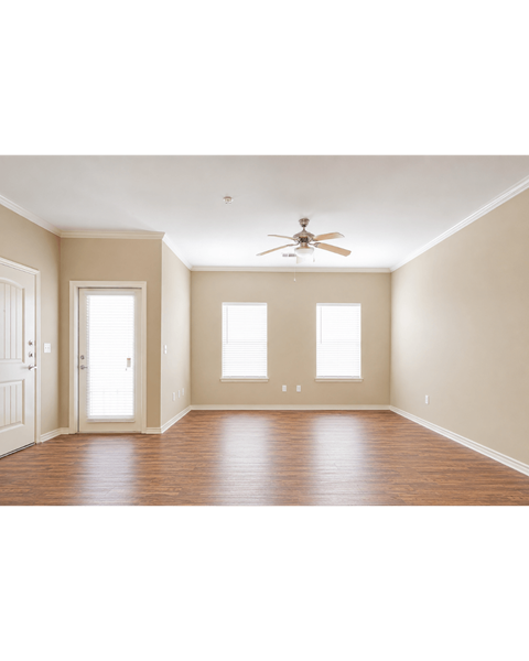 A room with a ceiling fan and three windows.