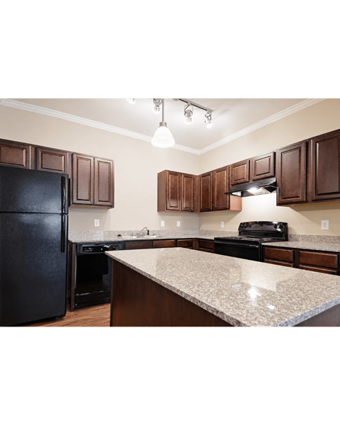 A kitchen with dark brown cabinets and a granite countertop.