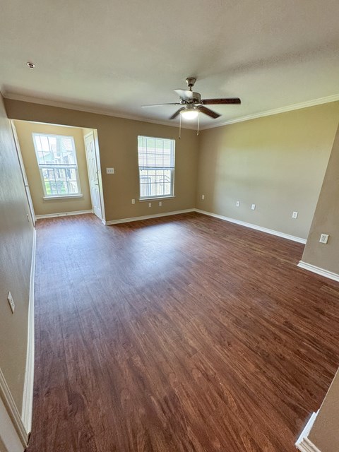 A room with wooden floors and a ceiling fan.