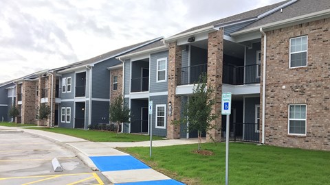 Apartment building with a blue painted area in front.