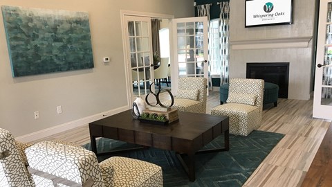 A living room with a fireplace and a painting on the wall.