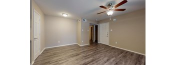 a living room with wood floors and a ceiling fan