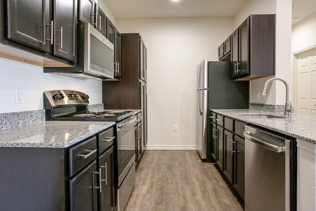 a kitchen with black cabinets and stainless steel appliances