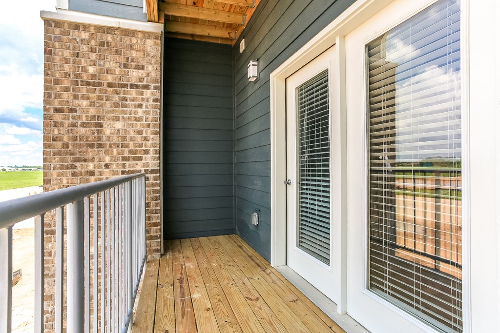 a porch with a door and a brick wall