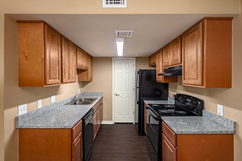 A kitchen with wooden cabinets and black appliances.