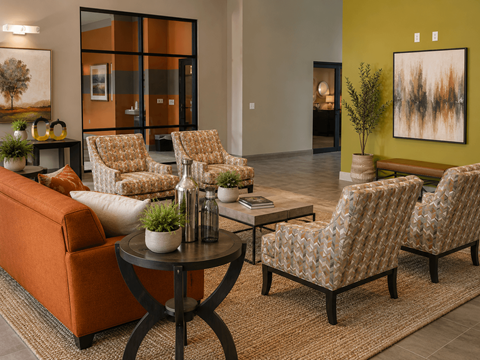 A living room with a sofa, two chairs, and a table with a plant on it.