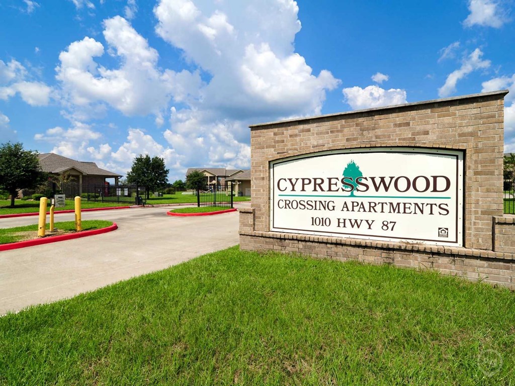 a sign for cypresswood crossing apartments in front of a building